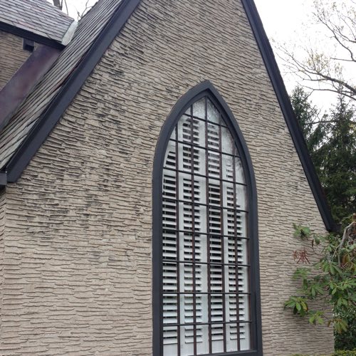 Exterior facade of stone home with plantation shutters